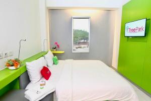 a room with a bed with a green wall at TreePark Hotel Jakarta Airport in Tangerang
