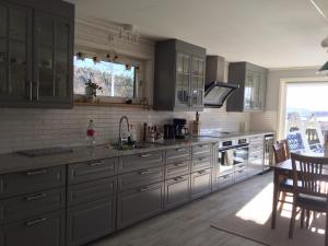 a kitchen with gray cabinets and a table and chairs at Rösselviks Gård in Rösselvik