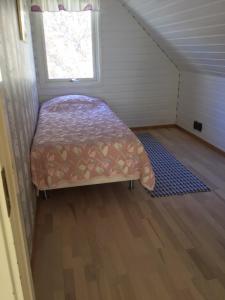 a small bed in a small room with a window at Rösselviks Gård in Rösselvik