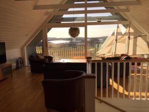 a living room with a large window with a sailboat at Rösselviks Gård in Rösselvik