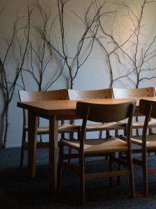 a table and chairs in a room with trees on the wall at 開土 KAIDO Hotel in Sapporo