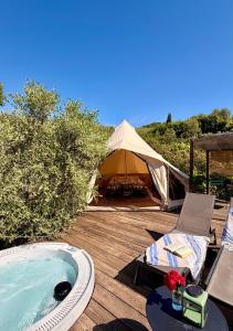 a tent and a jacuzzi tub on a wooden deck at Stecadó Glamping in Dolceacqua