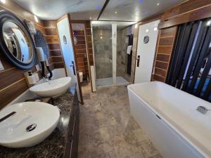 a bathroom with a sink and a tub and a toilet at Mała Anglia Deluxe Rooms & SPA in Sopot