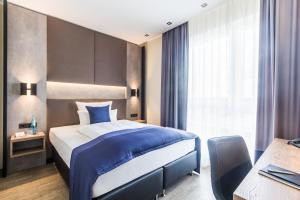 ein Hotelzimmer mit einem großen Bett und einem Schreibtisch in der Unterkunft SKY Hotel Cloppenburg in Cloppenburg