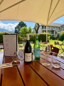a wooden table with wine bottles and glasses on it at Campanile Chambéry in Chambéry