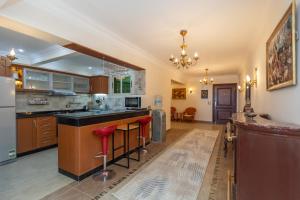 a large kitchen with a large island with red stools at 3BR Beach Front Chalet On RedSea in Ain Sokhna