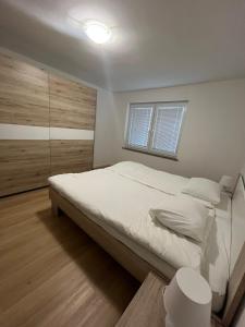 a bedroom with a large bed and a window at Janez house in Metlika