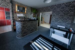 a living room with a kitchen with a counter at Wilanowska Hostel in Warsaw