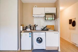 a laundry room with a washer and dryer at Jardins de Flore in Mérignac