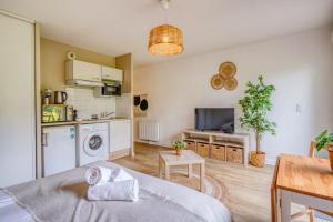 a living room with a bed and a kitchen at Jardins de Flore in Mérignac