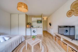 a living room with a couch and a table at Jardins de Flore in Mérignac