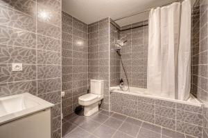 a bathroom with a toilet and a shower and a sink at Jardins de Flore in Mérignac +4 photos