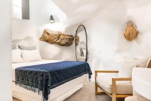 a bedroom with a bed in a room with a rock on the wall at Timedrops Santorini Villas-Private pool in Emporio +143 photos