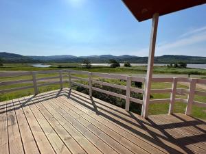 a wooden deck with a fence and a view of the water at Lochead Chalet 2 in Lochgilphead +2 photos