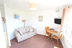 a living room with a couch and a table at Lochead Chalet 2 in Lochgilphead