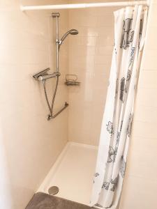 a shower with a shower curtain in a bathroom at Charming House Among the Prosecco Hills & Olive Groves in San Pietro di Feletto +7 photos