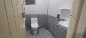 a bathroom with a white toilet and a sink at VR Colive in Kammasandra +38 photos