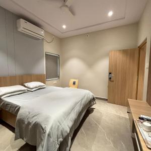 a bedroom with a large white bed and a window at Hotel Arunodaya Avenue in Srīkākulam +3 photos
