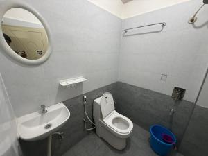 a bathroom with a sink and a toilet and a mirror at VR Colive in Kammasandra