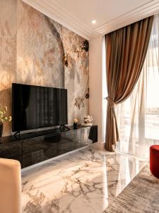 a living room with a flat screen tv on a wall at FIRST RESIDENCe in Mamaia