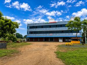 a building with a dirt road in front of it at Hotel Sabareesh Kanyakumari in Golden Rock