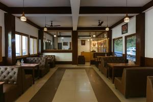 a restaurant with chairs and tables and windows at Chaman Vatika in Kasol +15 photos