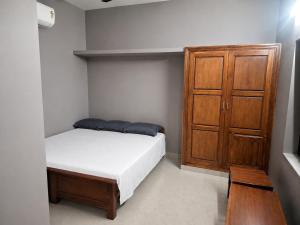 a bedroom with a bed and a wooden cabinet at Hotel Sabareesh Kanyakumari in Golden Rock