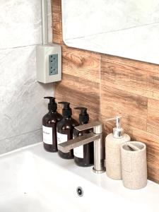 a bathroom sink with three bottles on it at Airport Cozy House - Suvarnabhumi in Samutprakarn +27 photos