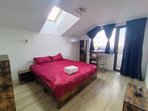 a bedroom with a bed with a red blanket at CASA Don Lucio in Craiova