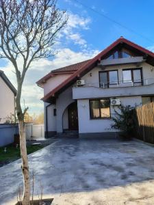 a white house with a tree in front of it at CASA Don Lucio in Craiova