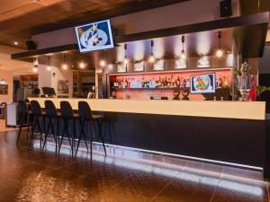 a bar with chairs and a tv above it at Park Inn by Radisson Central Tallinn in Tallinn