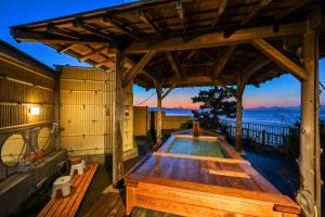 a hot tub on the deck of a house at Inatori Tokai Hotel Yuen in Higashiizu