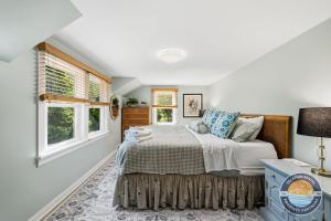a bedroom with a bed and two windows at Peaceful Lake Como Retreat in Lake Geneva