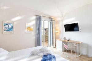 a bedroom with a bed and a desk and a television at Hotel Oasi Castiglione in Casamicciola Terme