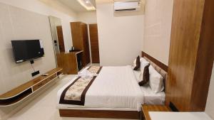a bedroom with a bed and a flat screen tv at Hotel Akshara Inn in Nasīrābād