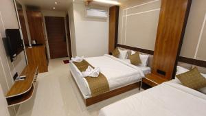 a hotel room with two beds and a television at Hotel Akshara Inn in Nasīrābād +19 photos