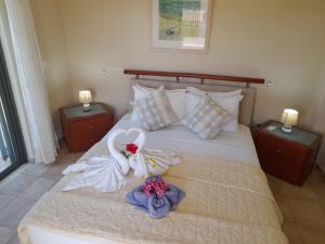 a bed with two robes on it with two flowers at Private Pool Villas in Svoronata