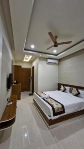 a bedroom with a bed and a ceiling fan at Hotel Akshara Inn in Nasīrābād