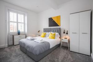 a bedroom with a large bed with yellow pillows at Fifty Two Old Elvet in Durham