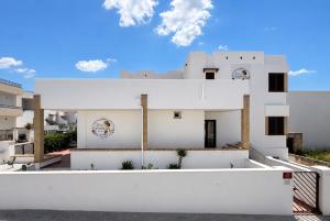 a white house with a white wall at Donna Ginevra Rooms - A soli 300m dalla Spiaggia in Lido Marini