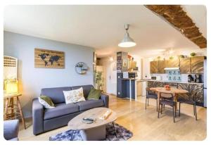a living room with a couch and a table at Chez Les Ch'Tis in Commes