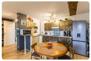 a kitchen with a wooden table and a kitchen with a table and chairs at Chez Les Ch'Tis in Commes +47 photos