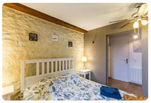 a bedroom with a bed and a ceiling fan at Chez Les Ch'Tis in Commes