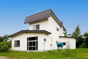 a white house with a metal roof at Cottage Abashiri in Abashiri