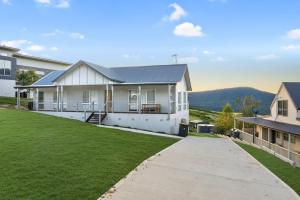 a large white house with a grass yard at Spotted Gum -Merrijig in Merrijig