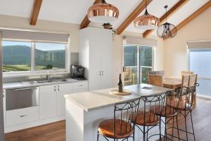 a kitchen with white cabinets and a table with chairs at Spotted Gum -Merrijig in Merrijig