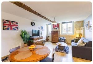 a living room with a table and a couch at Chez Les Ch'Tis in Commes