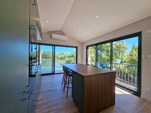 a kitchen with a island and large windows at Maison du Bord du Rhône in Saint-Pierre-de-Boeuf +15 photos