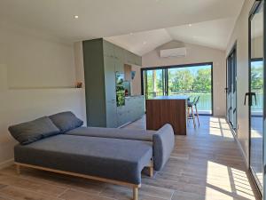 a living room with a couch and a kitchen at Maison du Bord du Rhône in Saint-Pierre-de-Boeuf