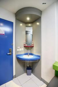 a bathroom with a blue sink and a mirror at TreePark Hotel Jakarta Airport in Tangerang